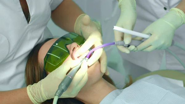 Assistente coloca ejetor de saliva na boca do paciente — Fotografia de Stock