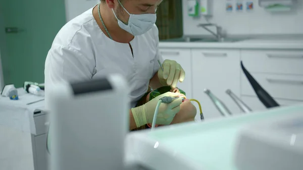 Zahnarzt putzt eine junge Frau — Stockfoto