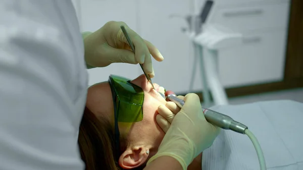 Tandarts houdt patiënten bovenlip en poetst haar tanden — Stockfoto