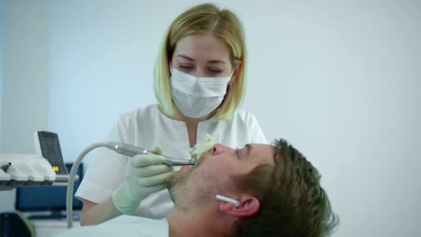 Dentista escova dentes com equipamentos elétricos — Vídeo de Stock