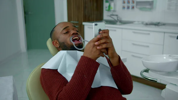 A fickó fogászati tágítóval a szájában ül. — Stock Fotó