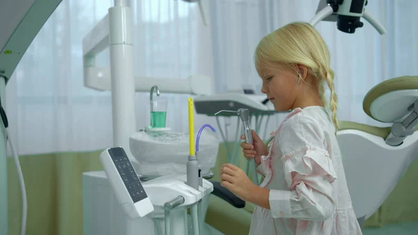 Menina verifica equipamentos odontológicos no armário — Fotografia de Stock