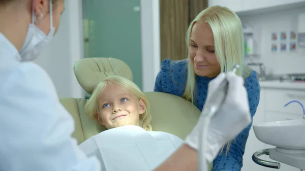 Стоматолог показує дівчині, як працює медична дриль — стокове фото