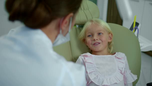 Niña habla con dentista y señala en su cara y boca . — Vídeos de Stock