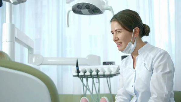 Dentiste parle à la fille et montre la longueur de quelque chose . — Photo