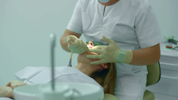 Tandarts brengt een tandheelkundige stof op een tand — Stockfoto