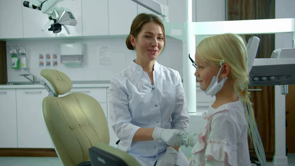 Chica da la mano con un médico y sonríe — Foto de Stock