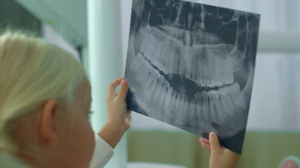 Девушка смотрит на рентген зубов в шкафу . — стоковое фото