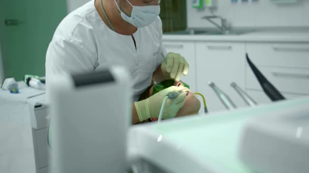 Dentist does a toothbrushing for a young woman — Stockvideo