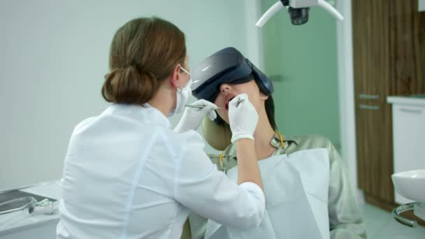 Odontólogo trabaja, chica se sienta con gafas de realidad virtual — Vídeo de stock