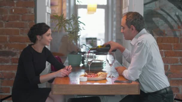 Couple dans un café, l'homme verse du vin dans des verres — Video