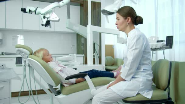 Zahnärztin spricht mit kleinem Mädchen in Klinik. — Stockvideo