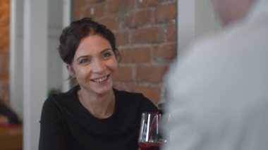 Evli çift yemekte konuşuyor, kadın gülüşlü adama bak.