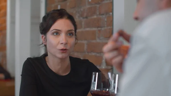 Mujer con una copa de vino hablando con el hombre en la cena — Foto de Stock