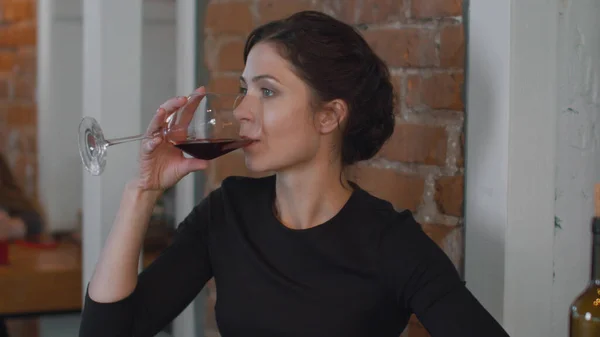 Lonely woman drinks wine and looks at the phone
