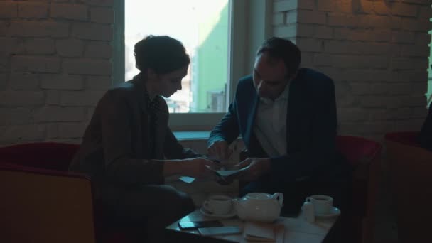 Affärspartners signerar dokument på ett café — Stockvideo