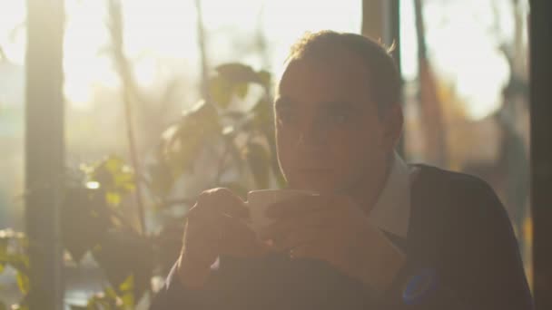 Homem bebe chá ou café em um café — Vídeo de Stock