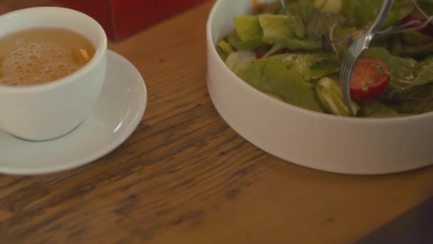 Primer plano del plato con ensalada, hombre comiendo una ensalada en la cafetería — Vídeos de Stock