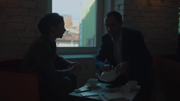 Spotkanie biznesowe, człowiek nalewa herbatę do kubka — Wideo stockowe