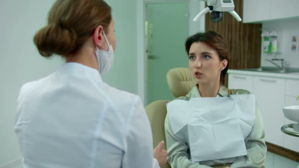Доктор розмовляє з дівчиною і щось їй пояснює — стокове відео