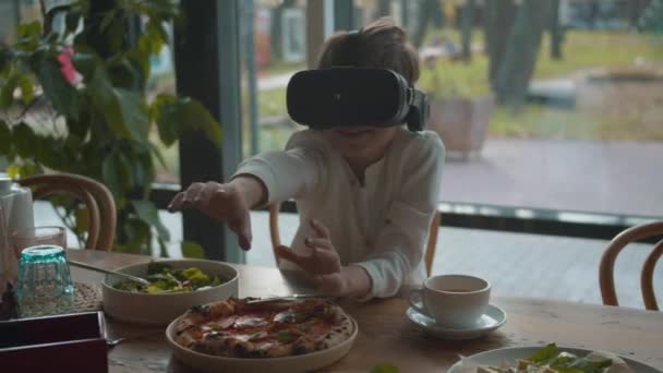 Menino brincar com óculos de realidade virtual no café — Vídeo de Stock