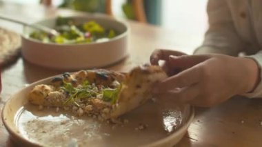 Çocuk bir dilim pizza alır ve yer.