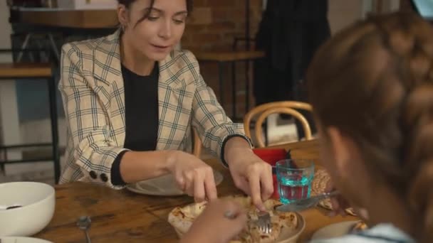 Kvinna tar en bit pizza och lägger på tallriken — Stockvideo