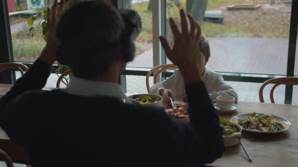 Muž ve virtuální realitě brýle v kavárně se synem — Stock video