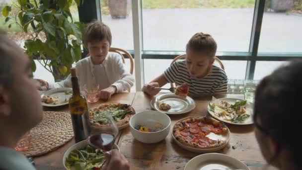 Vista superior, chico toma una comida de un plato, chica come pizza — Vídeo de stock