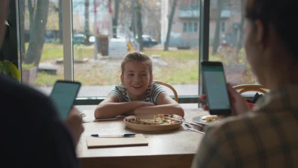 Dziewczyno, spójrz na jej rodziców, siedzących w rozmowie telefonicznej i uśmiechających się. — Wideo stockowe