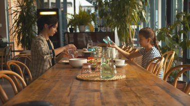 Sifde view, anne ve kızı öğle yemeği yiyor.