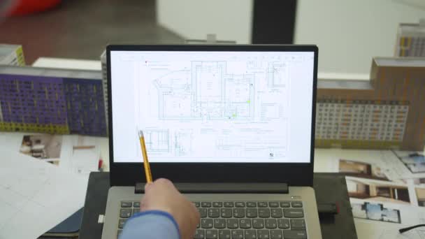 Man shows with pencil at the scheme of apartement on laptop — ストック動画