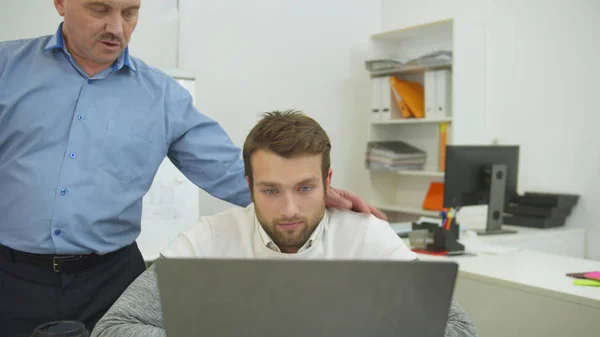 Cansado homem esquerdas para o trabalho, colegas de trabalho vivem no escritório e bater-lhe no ombro — Fotografia de Stock