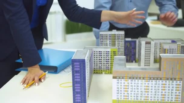Femme réorganiser les maisons sur la table dans le bureau 