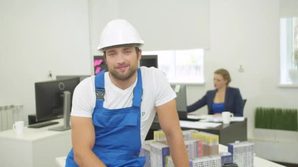 El constructor sonriente mira y asiente con la cabeza a la cámara — Vídeo de stock