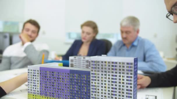 Zaměření na model domů, lidé pracují na pozadí — Stock video