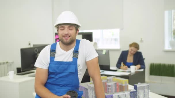 Oszołomiony budowniczy z rozmów kawy na aparacie z uśmiechem — Wideo stockowe