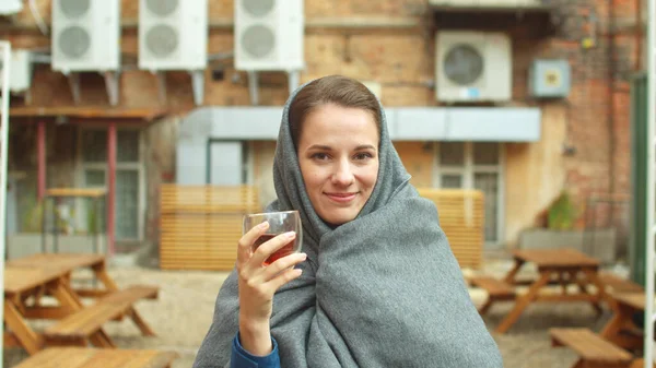 Mujer de pie en la calle, beber té y mirar a la cámara riendo —  Fotos de Stock