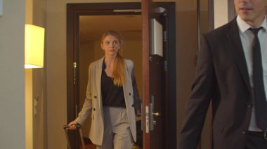 Takım elbiseli insanlar otel odasına çantalarla girdiler.