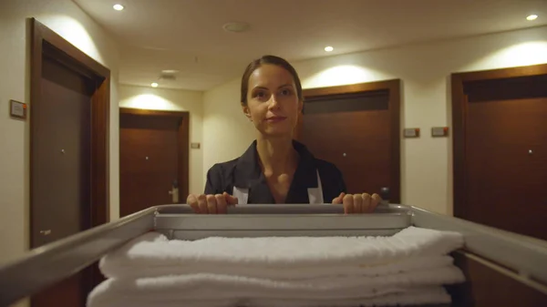 청소 도구를 가지고 호텔 복도를 지나는 가정부 — 스톡 사진