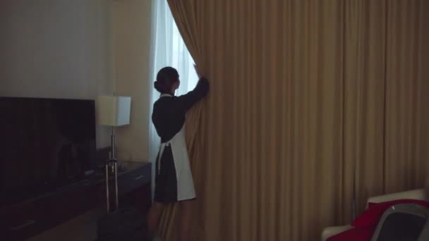 Husan öppnar gardinerna på fönstret i hotellrummet — Stockvideo