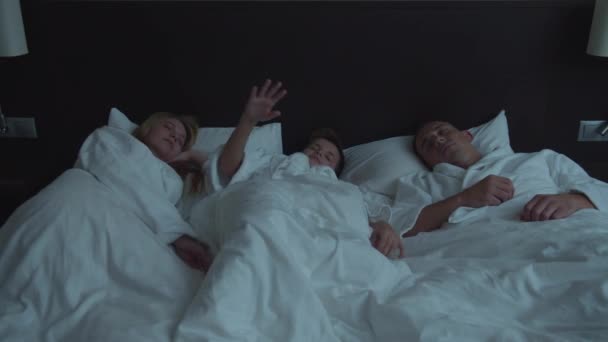Familie in het hotel, zoon kan niet slapen met ouders in een bed — Stockvideo