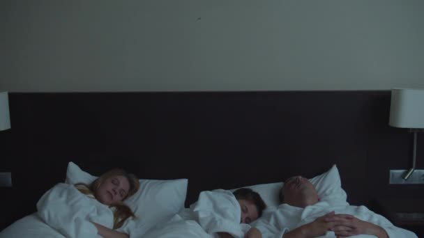Familie in het hotel, zoon slapen met ouders in een bed — Stockvideo