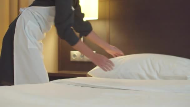 Housemaid κάνει ένα κρεβάτι και καλύτερα ένα μαξιλάρι στο δωμάτιο του ξενοδοχείου — Αρχείο Βίντεο