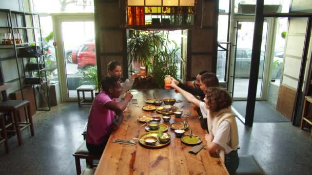 En cámara lenta, los amigos se reúnen en un café, se sientan y toman vasos — Vídeo de stock