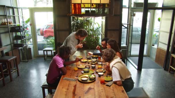 Compañía de amigos se reúnen en un café, comen comida — Vídeo de stock