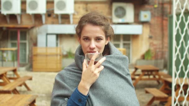 Flicka stå på gatan, dricka te och titta på kameran sorgset — Stockvideo