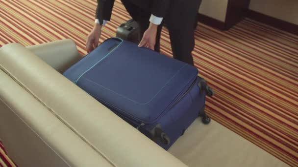 Muž otevřít kufr a dát své oblečení na pohovku — Stock video