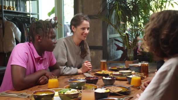 Grupo de amigos multiculturales sentarse en el almuerzo y niña contar una historia — Vídeos de Stock