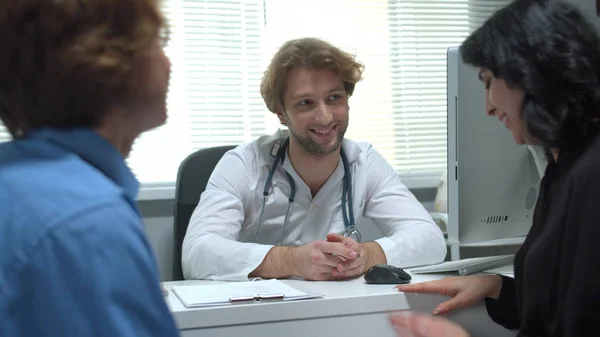 Doktor mluvit přátelsky s chlapcem a matkou v kabinetu nemocnice — Stock fotografie
